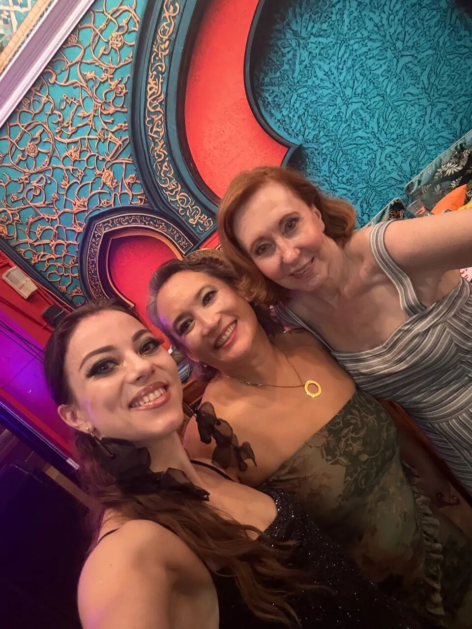 Selfie of three guests beneath the decorated ceiling at the August Hafla