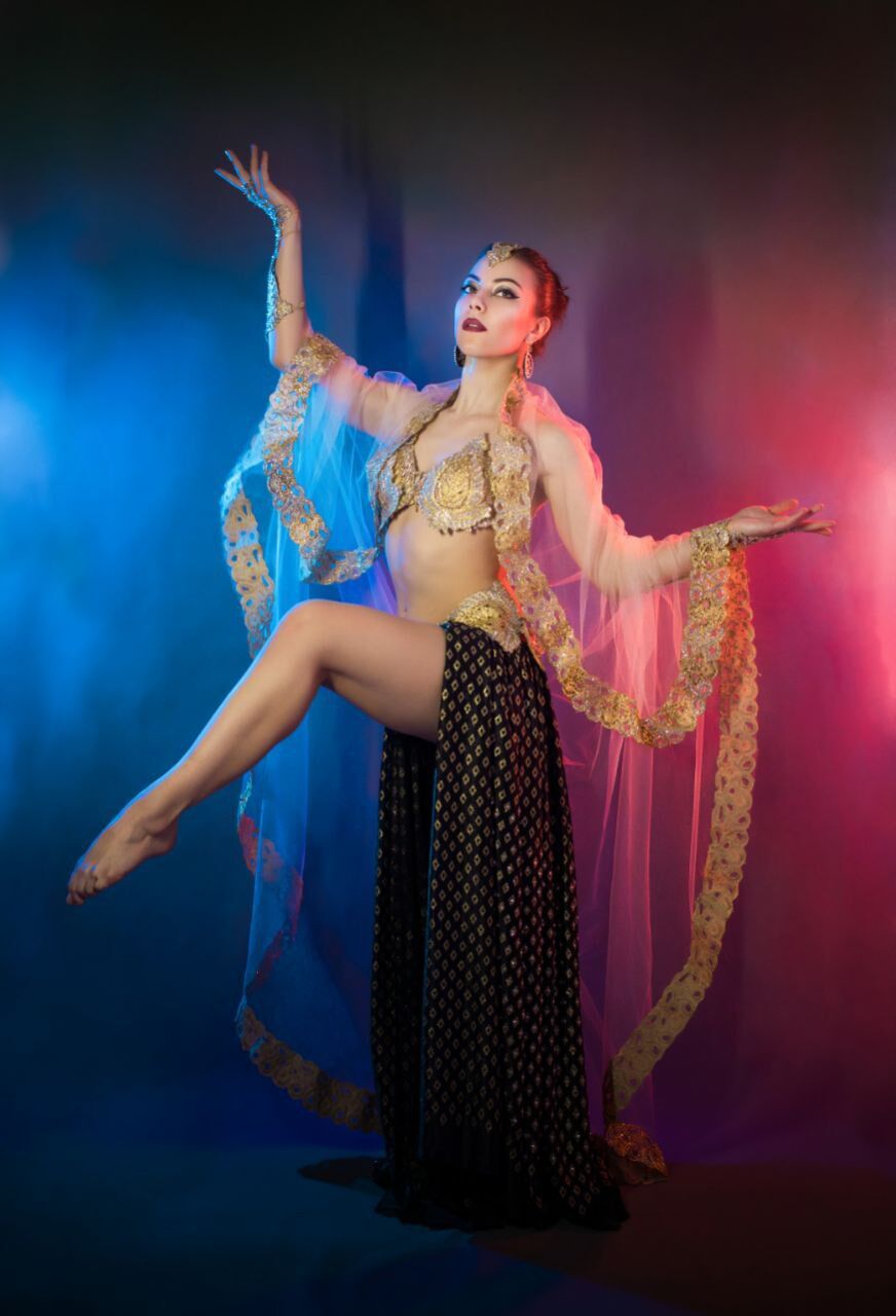 Elizabeth Khard in a dramatic pose with flowing gold-trimmed veils
