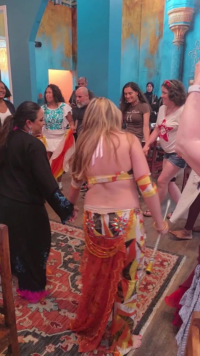 Guests and dancers filling the floor together at the July Hafla