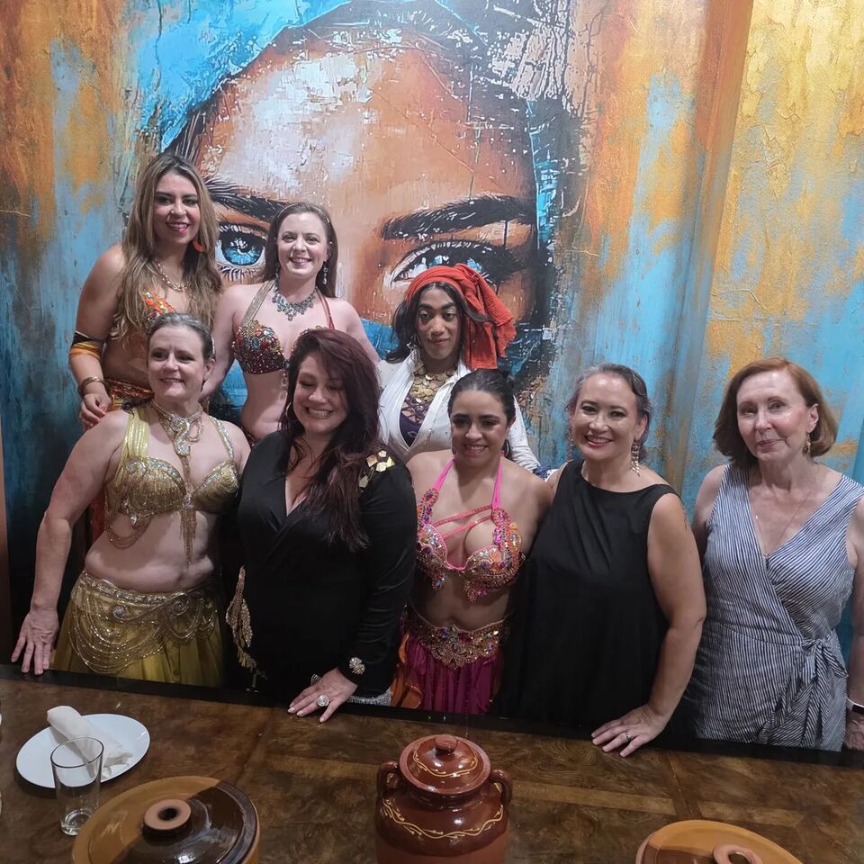 Group of dancers and guests posing together at the July Hafla
