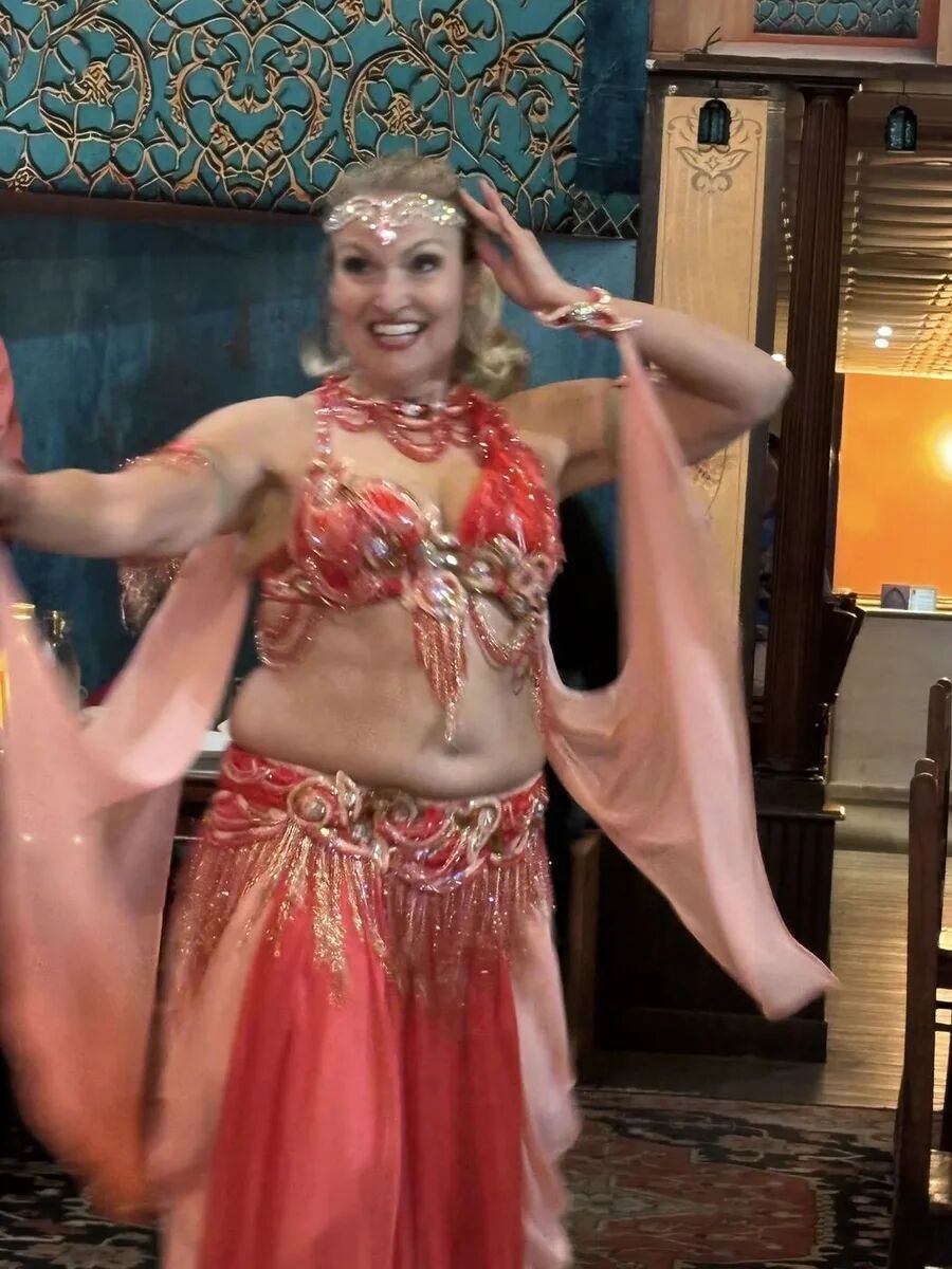 Dancer in red with flowing pink veils at the inaugural Hafla