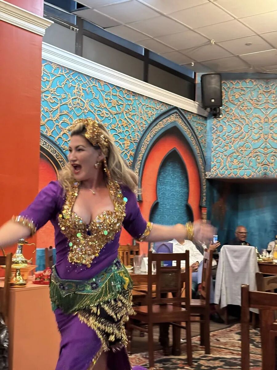 Dancer in purple and green mid-spin at the inaugural Hafla