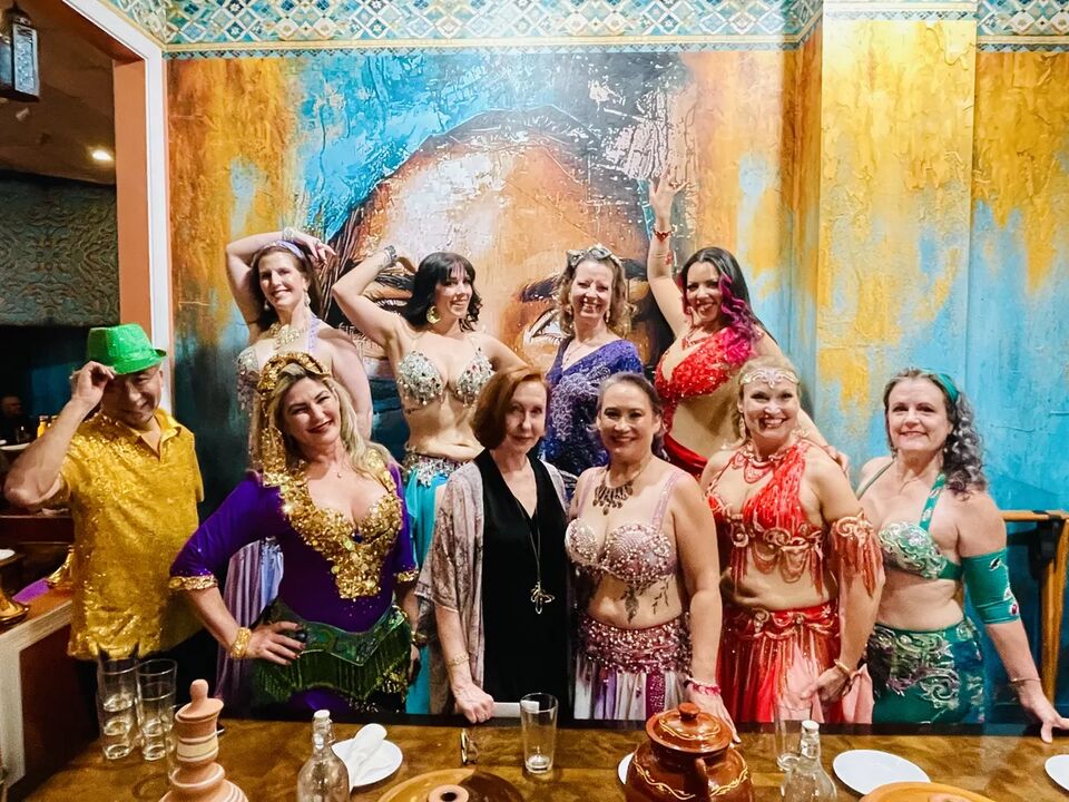 Dancers and guests of the inaugural Capital City Hafla gathered in costume in front of the mural at Marrakesh DC