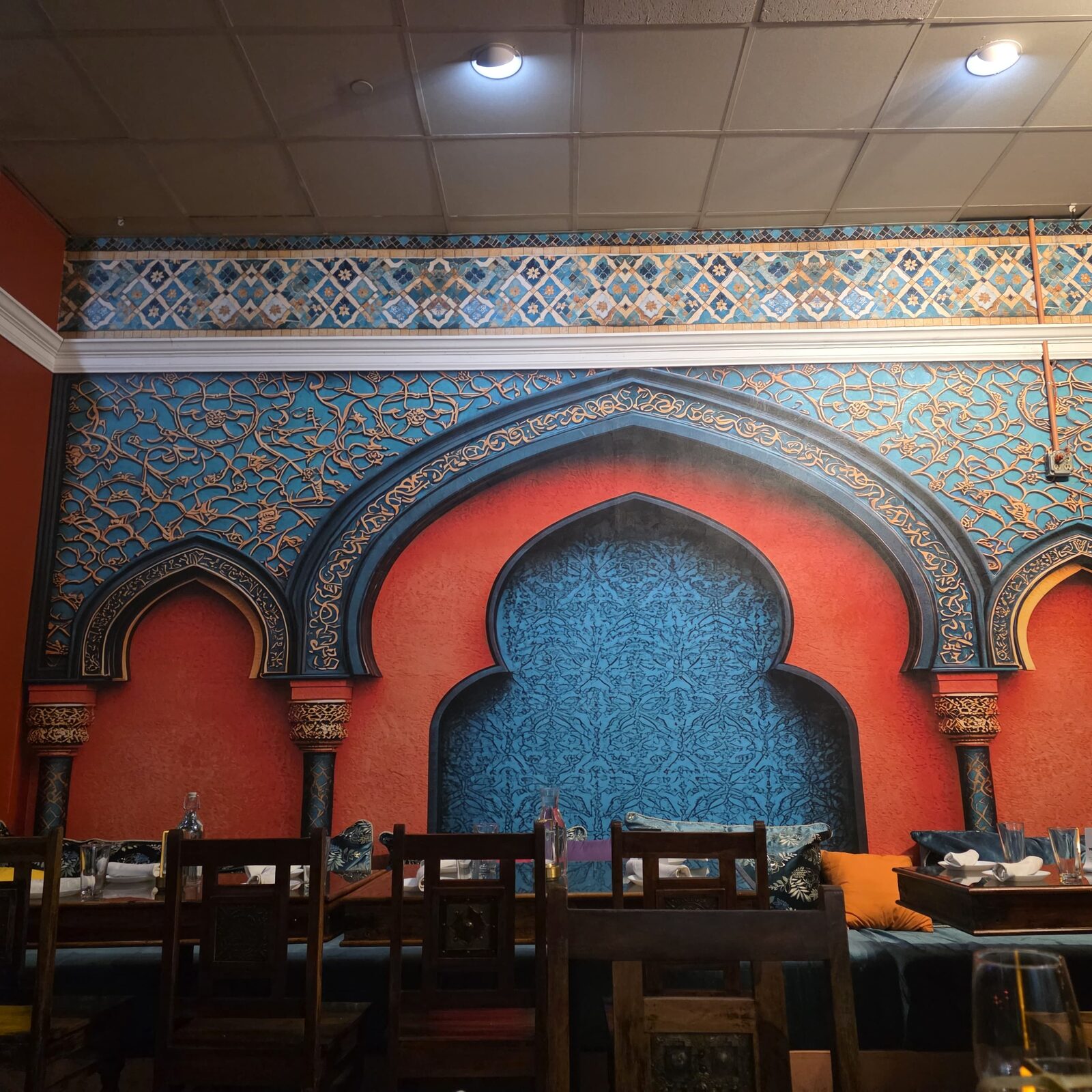 Hand-carved turquoise and terracotta Moorish arches along the dining room wall